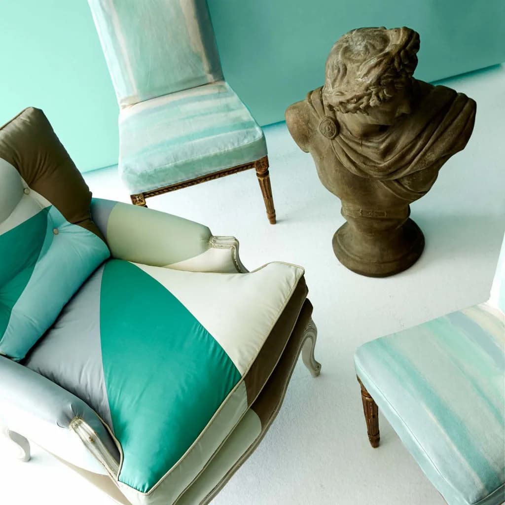 Turquoise and white bedroom interior with striped bedding, classical bust sculpture, and coordinated upholstered chairs by David Kaihoi.